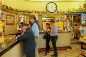 Locals and tourists drinking espresso standing at the marble counter of Sant'Eustachio Caffè, a historic coffee bar in Rome